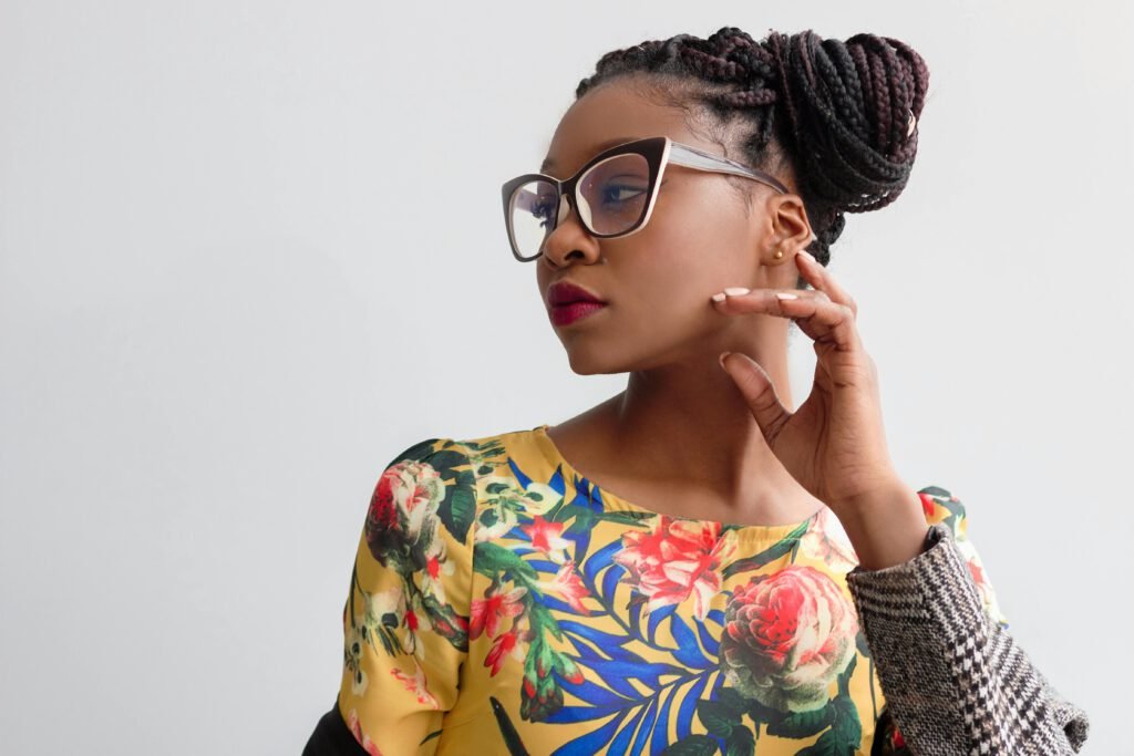 pexels-photo-871495-871495 Elegant portrait featuring a woman in glasses with braided hairstyle and floral top.